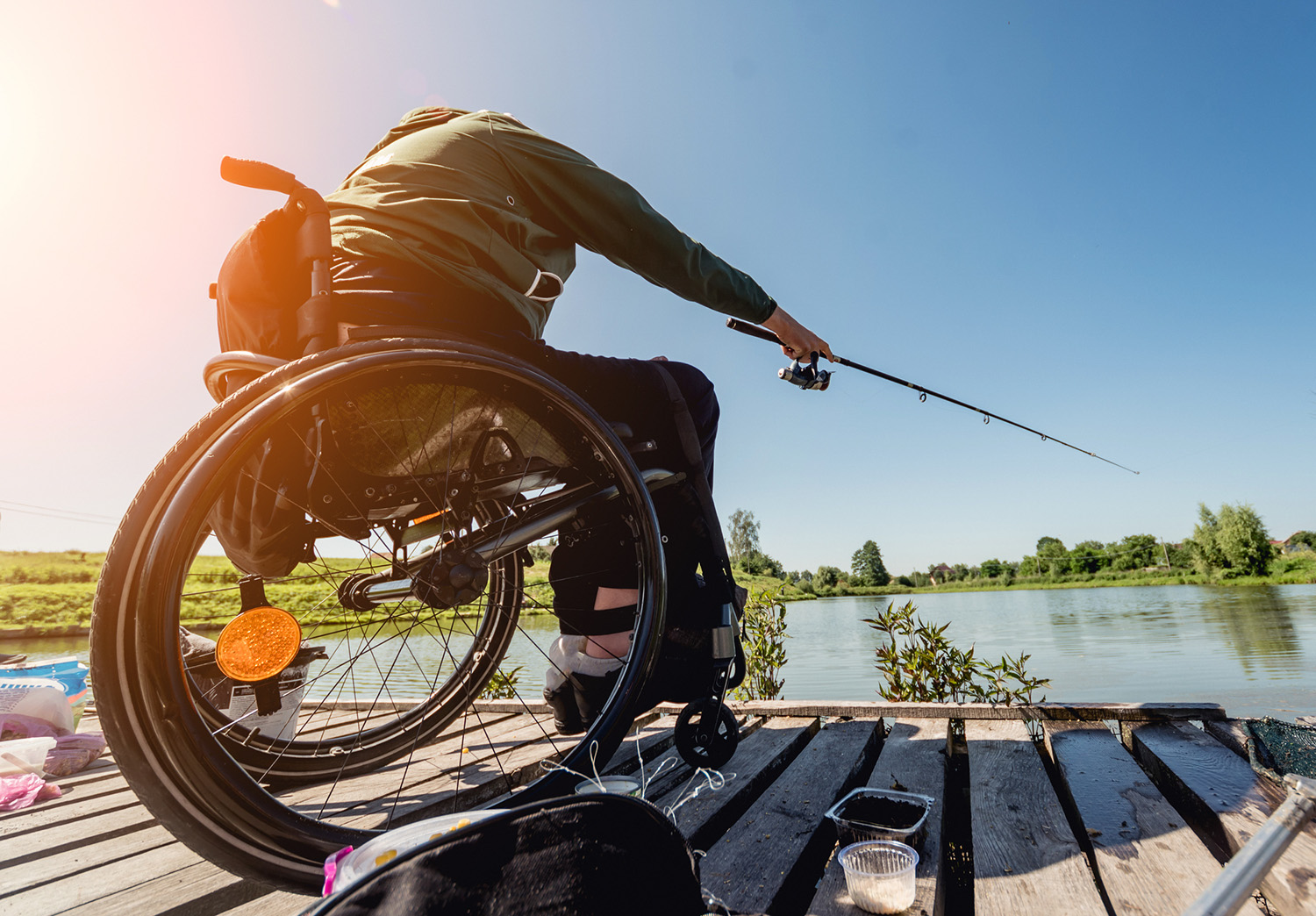 Young disabled man fishing from a dock