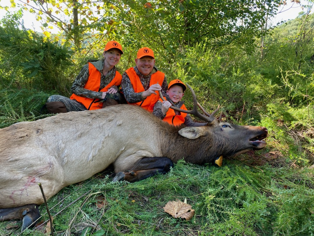 family of hunters and a harvested elk