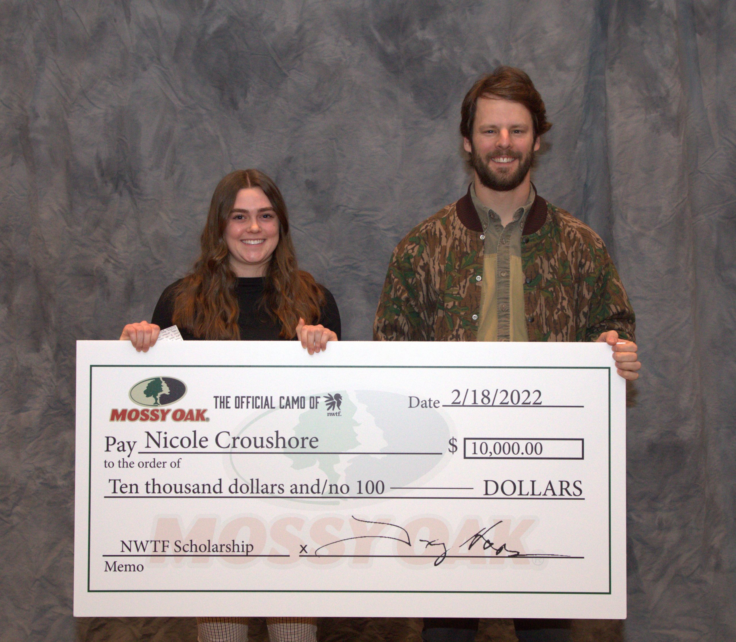scholarship winner with giant check and rep from Mossy Oak