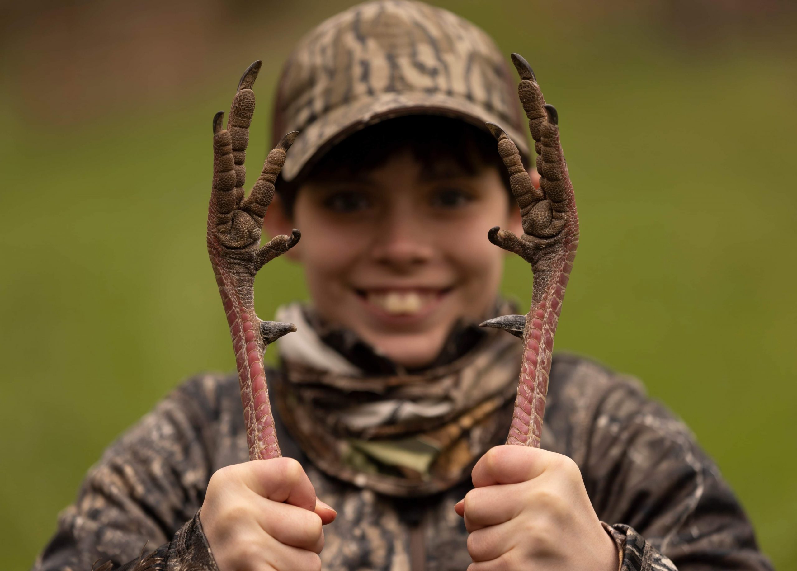 A youth holds a harvested wild turkey.