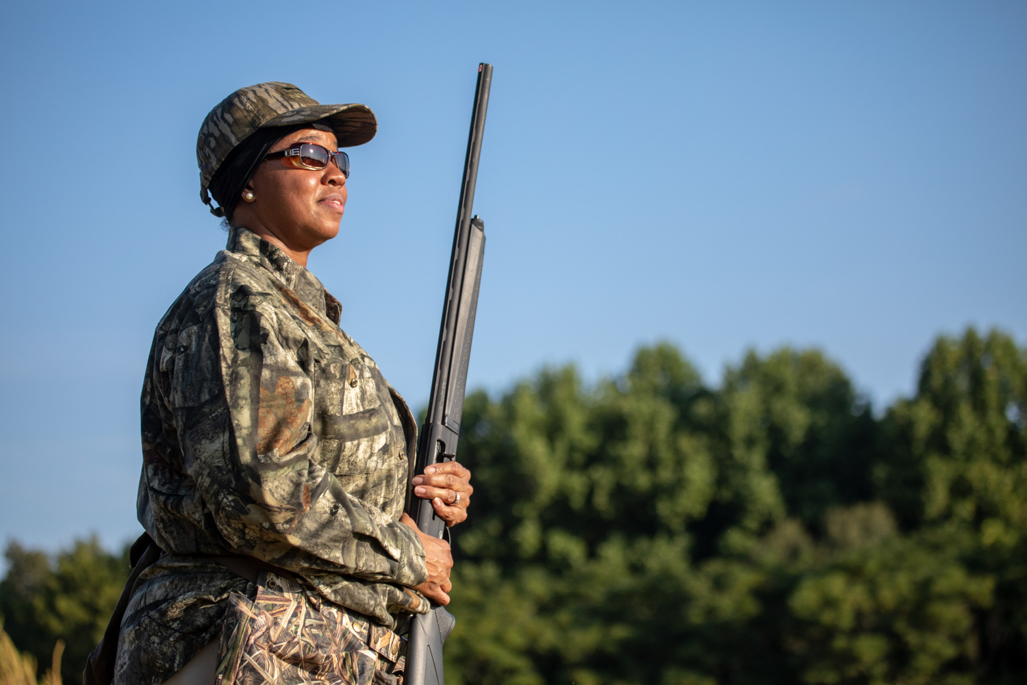 adult female holding a shotgun while dove hunting