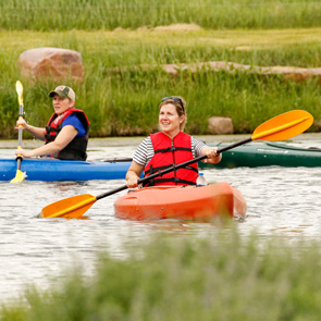 two women in kayaks on a pond